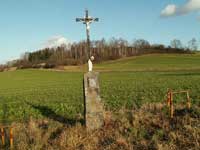 litinový křížek s kamenným podstavcem při silnici na Mlázovy u kolinecké Hůrky